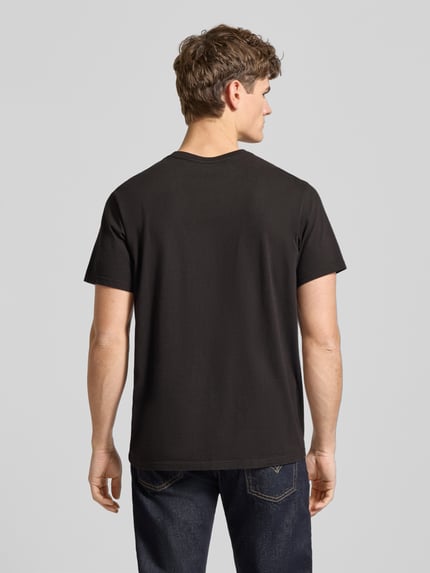 Männermodel trägt T-Shirt mit Label-Detail von Levi's®, schwarze Baumwolle, Relaxed Fit, Rückenlänge 70 cm, Ganzkörperansicht Rückansicht.