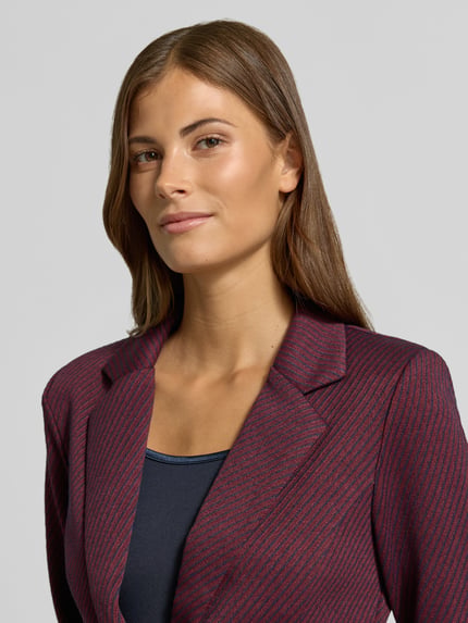 Vrouwenmodel draagt blazer met structuurpatroon van elastische materiaalmix met viscose, Model 'Kate' van ICHI, getailleerd, reverskraag, paspelzakken, knoopsluiting, donkerrood met zwart, Nahaufnahme Oberkörper.