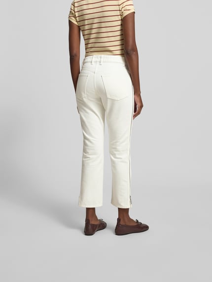 Modelka kobieca nosi Bootcut Fit Jeans in verkürztem Design od Rabanne, kremowa bawełna, 5 kieszeni, szerokość w rozmiarze 27: 68 cm, widok całej sylwetki z tyłu.