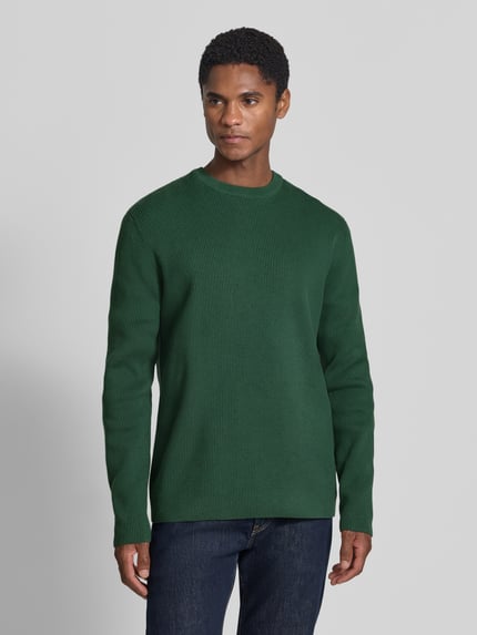 Männermodel trägt Slim Fit Strickpullover Baumwoll-Mix von Lindbergh, grün, gerippte Optik, Rundhalsausschnitt, Ganzkörperansicht von vorne.
