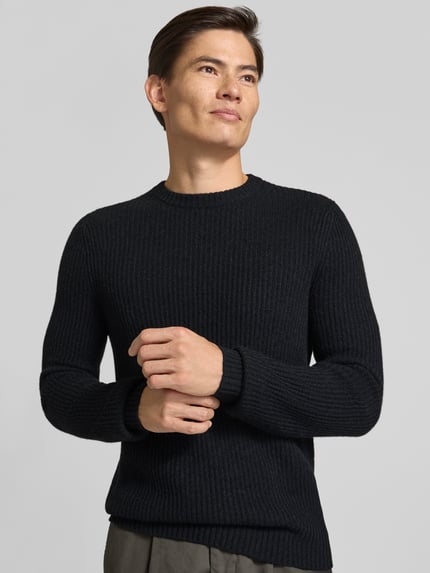 Männermodel trägt Strickpullover aus Kaschmir mit Rundhalsausschnitt von FTC Cashmere, gruby ścieg, prosty krój, okrągły dekolt, Długość tyłu 68 cm, Długość rękawów 72 cm, Ganzkörperansicht von vorne