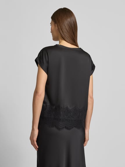 Kobiece modelka nosi T-shirt z okrągłym dekoltem 'ELLETTE' od Vila, luźny krój, satyna, koronka, czarny kolor, widok całkowity z tyłu.