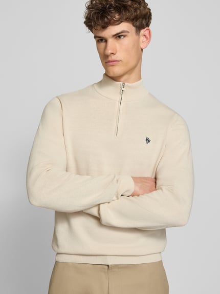 Männermodel draagt Troyer mit Logo-Stitching und kurzem ritssluiting van REVIEW in katoenmix, modern fit, schipperskraag, ribboorden, ruglengte maat M 65 cm, mouwlengte maat M 66 cm, lichte effen kleur, gladde textuur. Nahaufnahme Oberkörper.