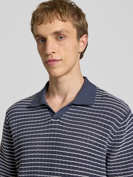 Männermodel trägt Regular Fit Poloshirt mit V-Ausschnitt von Jack & Jones, Strickshirt, Reine Baumwolle, gestreiftes Muster, Nahaufnahme Oberkörper.