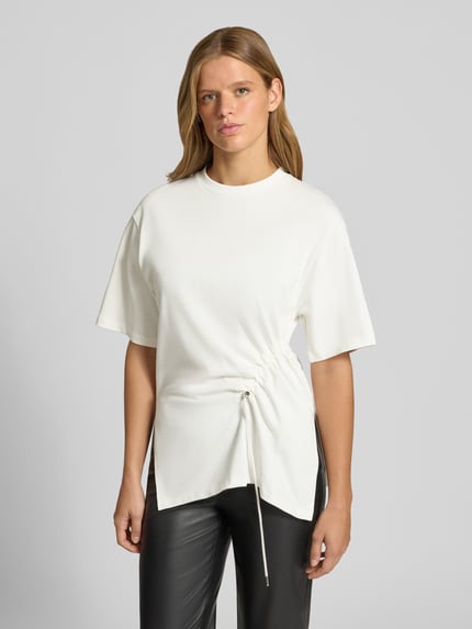 Frauenmodel trägt Longshirt mit Rundhalsausschnitt und Tunnelzug von Gina Tricot, reine Baumwolle, Relaxed Fit, Vorderansicht, Nahaufnahme Oberkörper.