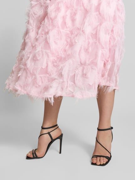 Frauenmodel trägt Cocktailkleid mit Fransen Modell 'PAZYLLA' von YAS, rosa, A-Linie, Midikleid, Nahaufnahme Unterkörper.