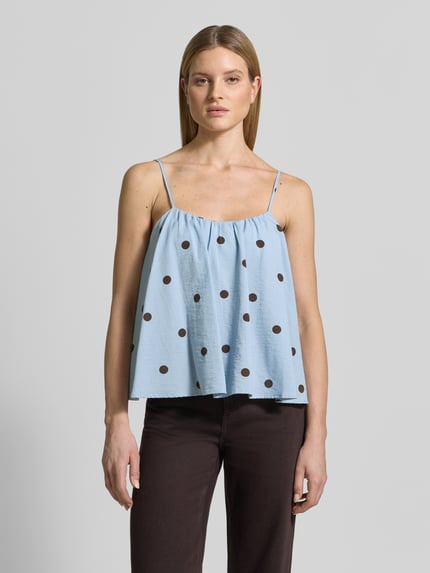 Frauenmodel trägt Blusentop mit tiefem Rundhalsausschnitt von Jake*s Casual aus Viskose-Baumwoll-Mix, Loose-Fit, Spaghettiträger, hellblau mit schwarzen Punkten, Rückenlänge bei Größe 36: 33 cm, Ganzkörperansicht von vorne.