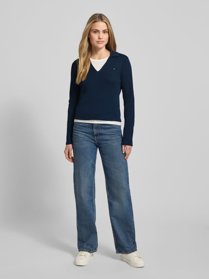 Vrouwenmodel draagt Slim Fit Langarmshirt uit pure katoen van Tommy Hilfiger, effen donkerblauw, met V-hals en logodetail, voorkant vollichaamsweergave.