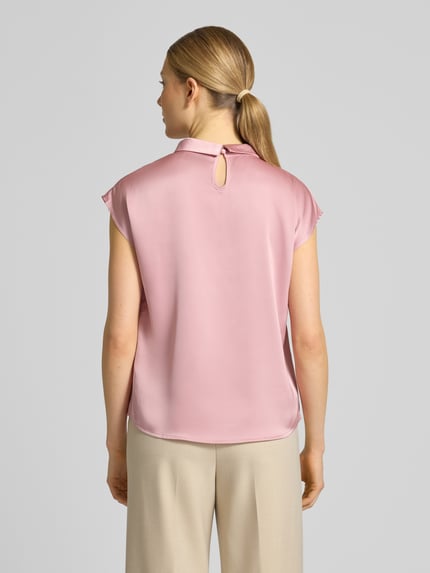 Frauenmodel trägt Blusenshirt aus Satin Modell 'Fleur' von Neo Noir in Rosa mit feiner Drapierung und Rundhalsausschnitt, Rückenlänge bei Größe 36: 58 cm, Regular-Fit, glatte Oberfläche, Ganzkörperansicht Rückansicht.