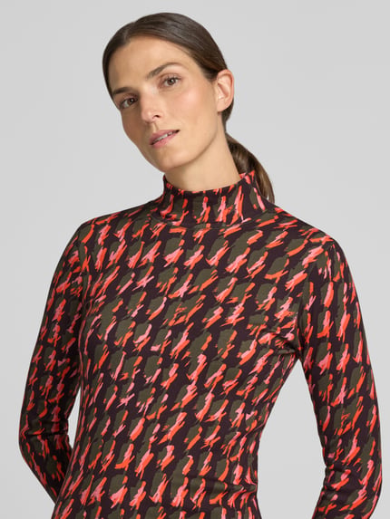 Kobiece model prezentuje bluzkę z długim rękawem z golfem Longsleeve mit Rollkragen von Marc Cain, mieszanka bawełny i elastanu, taliowany krój, prążkowana faktura, guziki przy zakończeniu rękawów, długość tyłu w rozmiarze 36: 58 cm, kolorowy wzór, Nahaufnahme Oberkörper.