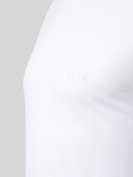 Männermodel trägt Regular Fit Langarmshirt aus reiner Baumwolle im 3er-Pack von BOSS, unifarbenes Jersey mit Label Stitching, Nahaufnahme Oberkörper.