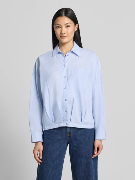 Frauenmodel trägt Regular Fit Hemdbluse aus reiner Baumwolle von Milano Italy in Hellblau mit Hemdblusenkragen, Brusttasche und Knopfleiste, Ganzkörperansicht von vorne. Kontext: Damen Hemdbluse, reine Baumwolle, Regular Fit, Hemdblusenkragen, Brusttasche, langärmeliges Design, Rückenlänge 56 cm, Ärmellänge 50 cm.