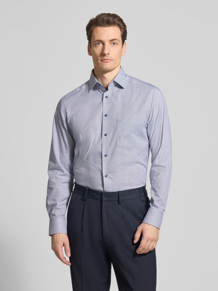 Männermodel trägt Regular Fit Business-Hemd mit Kentkragen von OLYMP, reine Baumwolle, hellblau, Brusttasche, Ganzkörperansicht von vorne.