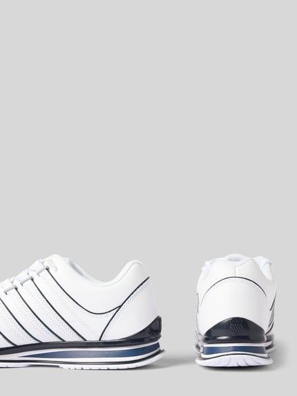 Produktfoto, białe sneakersy z powlekanej skóry model 'Rinzler' od K-SWISS, zaokrąglony kształt, wyprofilowana podeszwa, detale z logo, wysokość obcasa w rozmiarze 44: 3 cm, wysokość cholewki w rozmiarze 44: 9 cm, szerokość w rozmiarze 44: 9 cm
