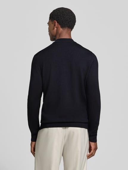 Männermodel trägt Regular Fit Pullover aus reiner Schurwolle Modell 'Davide' von JOOP! COLLECTION in Schwarz, Ganzkörperansicht Rückansicht.
