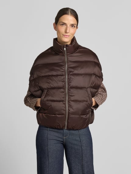 Frauenmodel trägt Steppweste mit Stehkragen und Eingrifftaschen von Milano Italy in Braun, entspannte Passform, Ganzkörperansicht von vorne, Rückenlänge 59 cm, Schulterbreite 50 cm, Brustweite 63 cm.