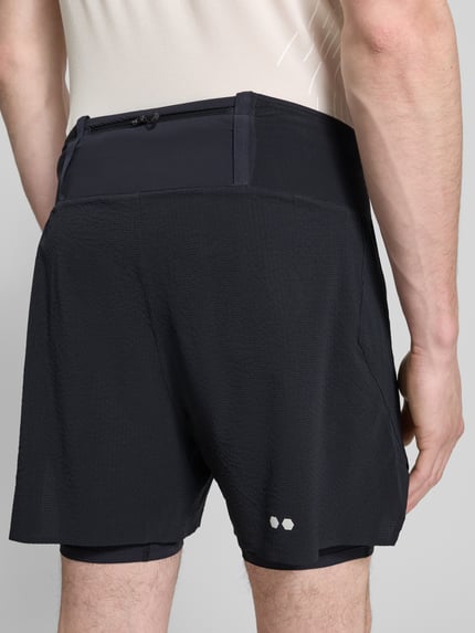Mannenmodel draagt Shorts im 2-in-1-Look Modell 'SENSE AERO 2IN1' van Salomon in zwart, regular fit, materiaal-mix met stretch, detailopname rugaanzicht.