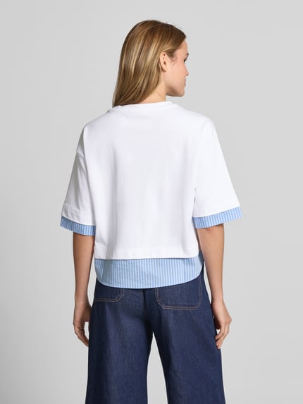Frauenmodel trägt T-Shirt mit Paillettenbesatz und Rundhalsausschnitt von Smith and Soul, Reine Baumwolle, Boxy-Fit, Rückenlänge 54 cm, Ganzkörperansicht Rückansicht.
