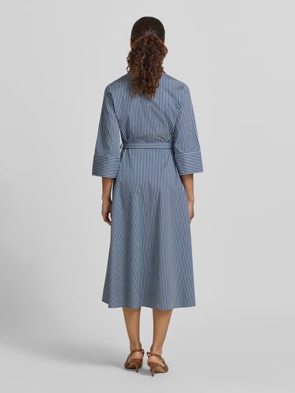 Frauenmodel trägt Hemdblusenkleid mit Bindegürtel und Knopfleiste von Zero im taillierten Schnitt, blau-weiß gestreifter Baumwoll-Mix, Midikleid, Ganzkörperansicht Rückansicht.