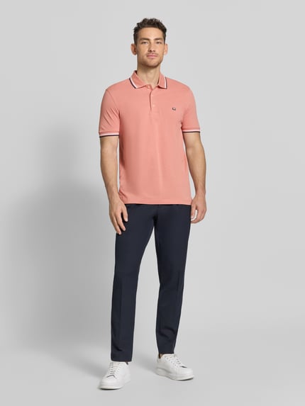 Männermodel trägt Regular Fit Poloshirt mit Kontraststreifen von Christian Berg Men aus Reine Baumwolle, Ganzkörperansicht von vorne.