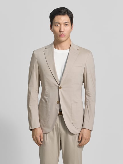 Männermodel trägt Sakko mit Reverskragen Modell 'Dallas' van JOOP! Collection in beige, regular fit, katoenmix, borstzak, klepzakken, knoopsluiting, rechte textuur, volledige lichaamsaanzicht van voren.