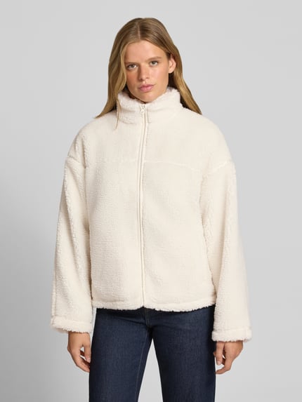 Frauenmodel trägt Teddyjacke mit Stehkragen von REVIEW in Creme, weiches Teddyfell, Reißverschluss, Regular Fit, Ganzkörperansicht von vorne.