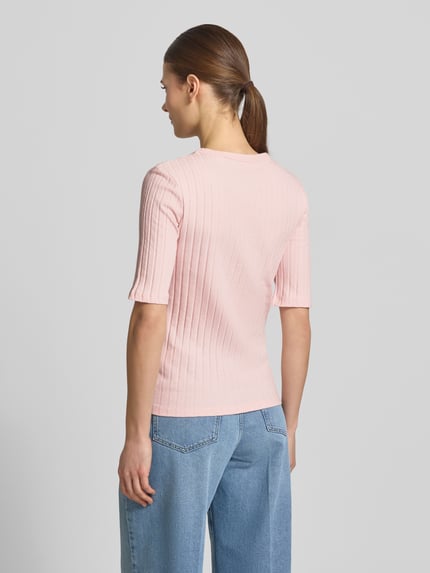Frauenmodel trägt T-Shirt in Ripp-Optik Modell 'Savka' von OPUS in zartem Rosa, Slim Fit, Halbarm, Material-Mix mit Stretch, Ganzkörperansicht Rückansicht.