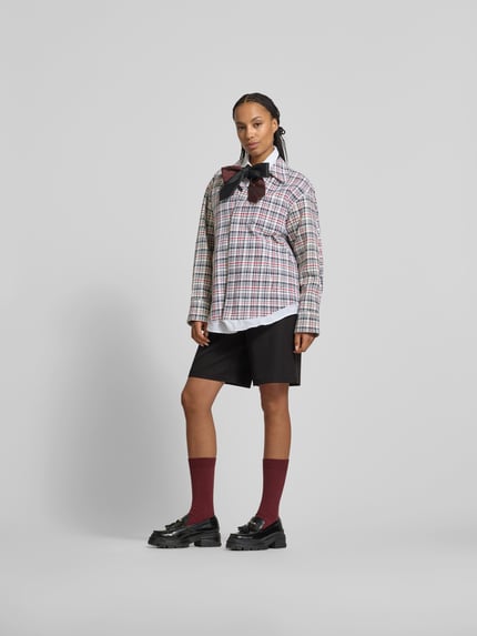 Kobiecy model nosi Jacke mit Leinen-Anteil od Victoria Beckham, bawełniano-lniana mieszanka, krój loose fit, kołnierz wykładany, kieszenie na piersi i wpuszczane, zapięcie na guziki, długość tyłu w rozmiarze XS/S: 81 cm, szerokość w rozmiarze XS/S: 78 cm, długość rękawa w rozmiarze XS/S: 62 cm, kolorowa krata, widok całej sylwetki z przodu.