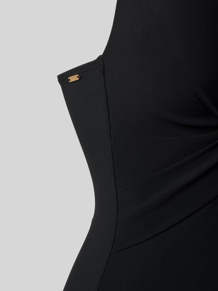 Frauenmodel trägt Badeanzug mit tiefem V-Ausschnitt Modell 'SOLID' von Barts im schwarzen Material-Mix mit Stretch-Anteil, Nahaufnahme Oberkörper.