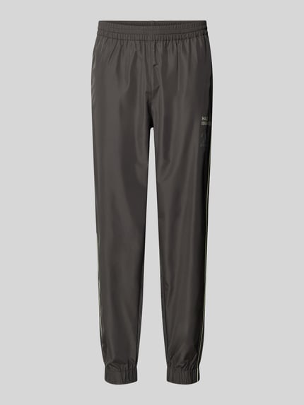 Produktfoto, Trainingshose mit elastischem Bund von HALO, krój relaxed fit, nadruk z logo, kieszenie zapinane na zamek błyskawiczny, długość wewnętrzna nogawki w rozmiarze M: 40 cm, ciemnoszary kolor, gładka tekstura