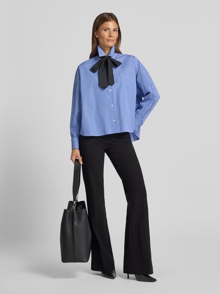 Frauenmodel trägt schwarze Regular Fit Schlaghose aus Viskose-Mix Modell 'NANOU' von SEDUCTIVE, kombiniert mit blauer Bluse, Ganzkörperansicht von vorne. Damen Schlaghose von SEDUCTIVE.