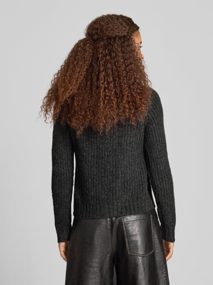 Frauenmodel trägt Regular Fit kardigan rozpinany z dodatkiem wełny model 'ASHLEY CARDIGAN' od Pepe Jeans, kolor jednolity, imitacja dzianiny, faktura, krój regular fit, długość krótka, ozdobne guziki, listwa guzikowa na całej długości, okrągły dekolt, długi rękaw, raglanowe rękawy, prążkowane zakończenia rękawów i dołu, wykończenie: dzianina, drobny splot, prążkowana dzianina, widok całej sylwetki z tyłu.