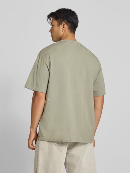 Männermodel trägt Regular Fit T-Shirt aus reiner Baumwolle Modell 'Painter' von Carhartt Work In Progress in Beige, Ganzkörperansicht Rückansicht. Herren T-Shirt, Label-Detail, Rückenlänge bei Größe M: 72 cm.