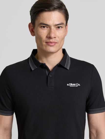 Męski model nosi Regular Fit Poloshirt aus Baumwoll-Mix od s.Oliver RED LABEL, bawełniany piqué, czarny, nadruk z logo, krótkie rękawy, kołnierzyk polo, widok z przodu, zbliżenie na górną część ciała.