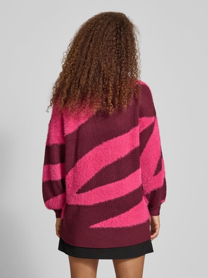 Frauenmodel trägt Loose Fit Strickpullover mit Rundhalsausschnitt Modell 'BLAIR' von Noisy May, pink-bordeaux Allover-Look, Rückenansicht.