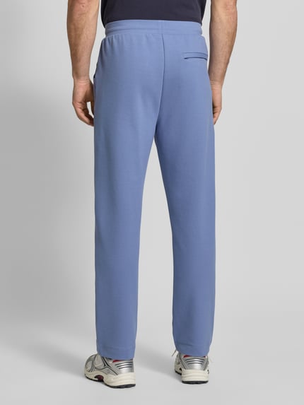 Männermodel trägt Regular Fit Sweatpants aus katoenmix model 'JT_Member Hurley' van BOSS Green, effen blauw met label stitching en vaste vouwen, elastische tailleband, zijzakken, nepachterzak, sweatstof, ganzkörperansicht rückansicht.