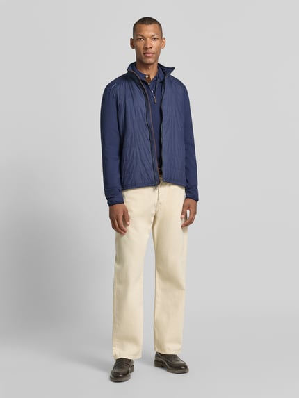 Männermodel trägt Relaxed Fit Sweatjacke mit Reißverschluss von Polo Ralph Lauren in Dunkelblau, helle Hose, Ganzkörperansicht von vorne.