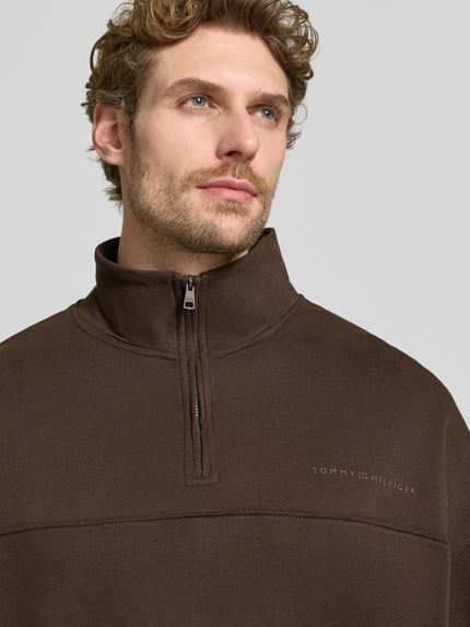 Männermodel trägt Relaxed Fit Sweatshirt aus Baumwoll-Modal-Mix von Tommy Hilfiger in Dunkelbraun, Nahaufnahme Oberkörper. Herren Sweatshirt