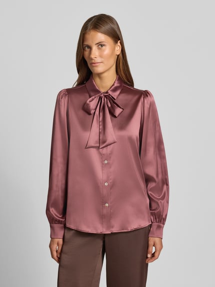 Vrouwenmodel draagt Regular Fit Hemdbluse aus Satin van Christian Berg Woman Selection in glanzende satijn, met sierstrik, overhemdkraag en lange mouwen, kleur oudroze, detailopname van bovenlichaam.