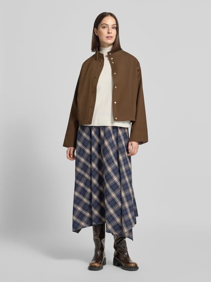 Frauenmodel trägt Midi-Rock mit asymmetrischem Saum Modell 'VMTILDA' von VERO MODA, kariertes Allover-Muster, Webware, Ganzkörperansicht von vorne.