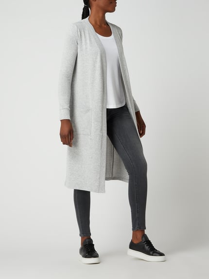 Frauenmodel trägt Longcardigan mit aufgesetzten Taschen Modell 'CITY' von Noisy May, Material-Mix mit Stretch-Anteil, Regular Fit, hellgrau, glatte Textur, Rückenlänge bei Größe S 107 cm, Ärmellänge 63 cm, Ganzkörperansicht von vorne.