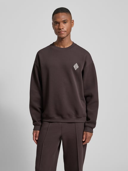 Männermodel trägt Loose Fit Sweatshirt aus Baumwoll-Mix von Lacoste, Optik: Unifarben, Logo-Stitching, Ganzkörperansicht von vorne.