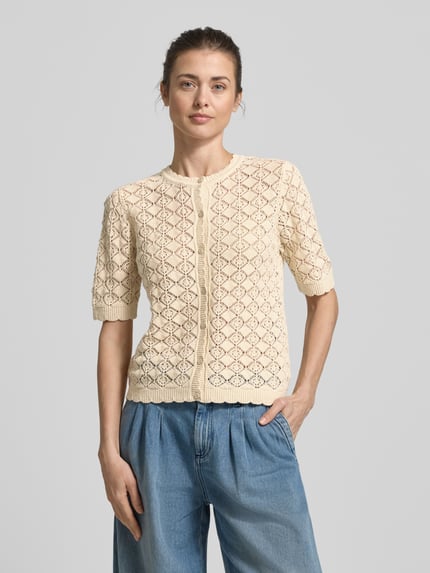Frauenmodel trägt Regular Fit Strickjacke aus reiner Baumwolle Modell 'SOFIA' von Selected Femme, Optik: Unifarben, Ajour-Strick, Nahaufnahme Oberkörper.