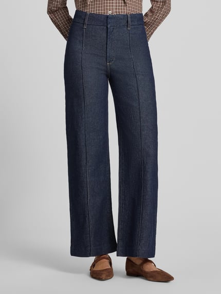 Frauenmodel trägt Wide Leg Jeans mit Ziernähten Modell 'PALOMA' von MANGO in Dunkelblau, strukturierte Oberfläche, Ganzkörperansicht von vorne, Damen Wide Fit, Haken- und Reißverschluss, seitliche Eingrifftaschen, Gesäßtaschen, Bundweite Größe 36: 37 cm, Innenbeinlänge 75 cm.