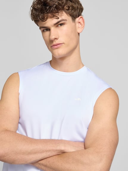 Männermodel trägt Relaxed Fit Top mit Logo-Print Modell 'OLIOS' von Ellesse in Weiß, elastisch, Rundhalsausschnitt, Nahaufnahme Oberkörper.