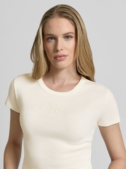 Frauenmodel trägt Damen T-Shirt Slim Fit T-Shirt aus Baumwoll-Mix Modell 'DELANOR' von HUGO, Optik: Unifarben, Label-Stitching-Applikation, Rundhals, Kurzarm, Materialverarbeitung: Jersey, Nahaufnahme Oberkörper.