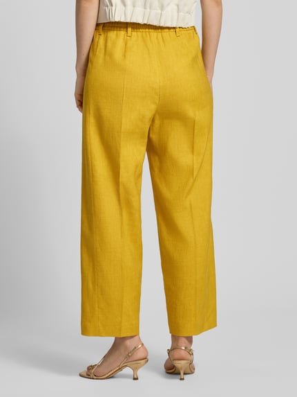 Frauenmodel trägt Wide Leg Hose aus Leinen-Mix von Windsor in Gelb mit Bügelfalten, Elastischer Bund, Damen, Ganzkörperansicht Rückansicht. Bundweite bei Größe 36: 38 cm, Innenbeinlänge: 67 cm, Lyocell-Anteil.