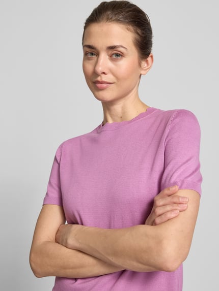 Frauenmodel trägt Strickshirt mit Rundhalsausschnitt mit Wellensaum von Zero in Flieder, körpernaher Schnitt, 1/2-Arm, Nahaufnahme Oberkörper.