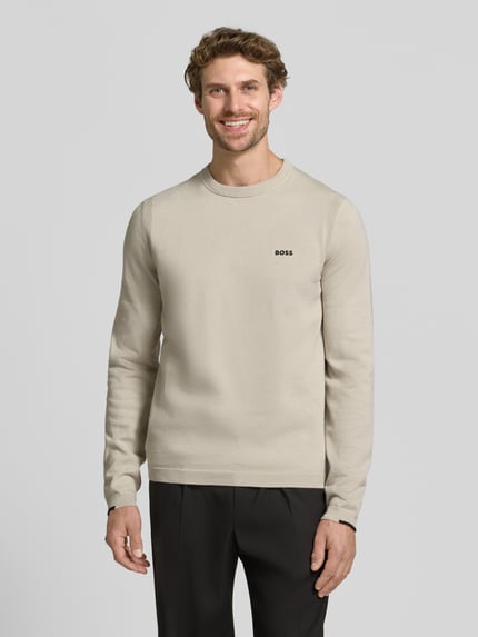 Męski model nosi jasnobeżowy sweter z bawełny Regular Fit Pullover aus reiner Baumwolle Modell 'KN_Ever-X' von BOSS Green, widok całej sylwetki z przodu.