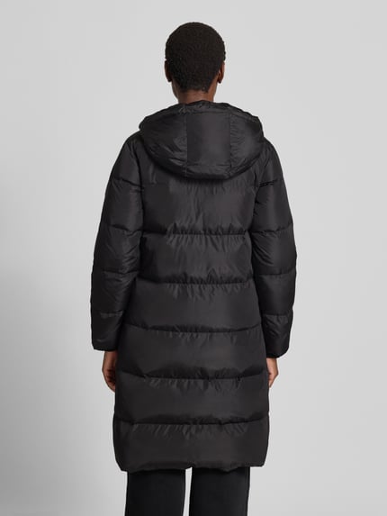 Frauenmodel trägt Steppmantel mit Zweiwege-Reißverschluss von Armani Exchange in Schwarz, Kapuze, Reißverschlusstaschen, Ganzkörperansicht Rückansicht.